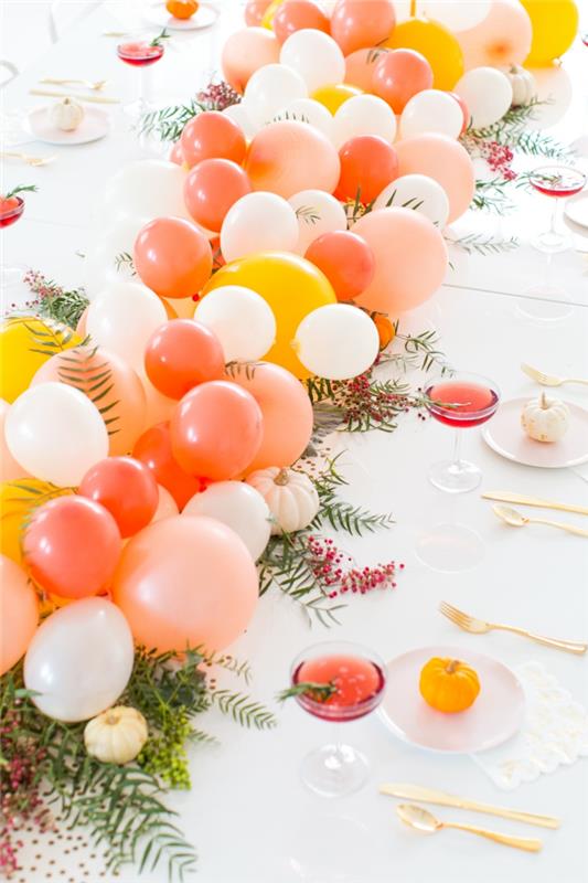 stalo dekoravimas balionų ir rozmarinų šakelių, balta staltiesė, raudono sidro taurės, gražiai dekoruotas stalas