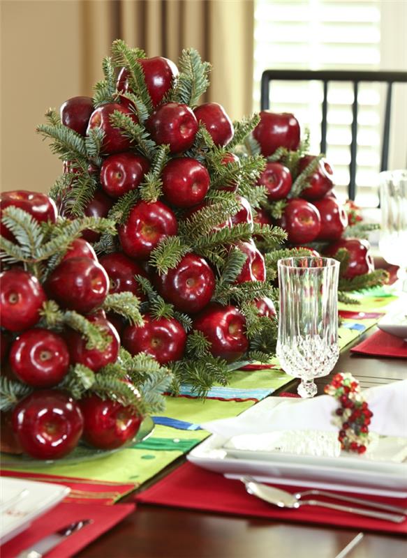 stalo dekoravimas raudonai ir baltai, dirbtiniai raudoni obuoliai, krištolinis puodelis, raudonos servetėlės