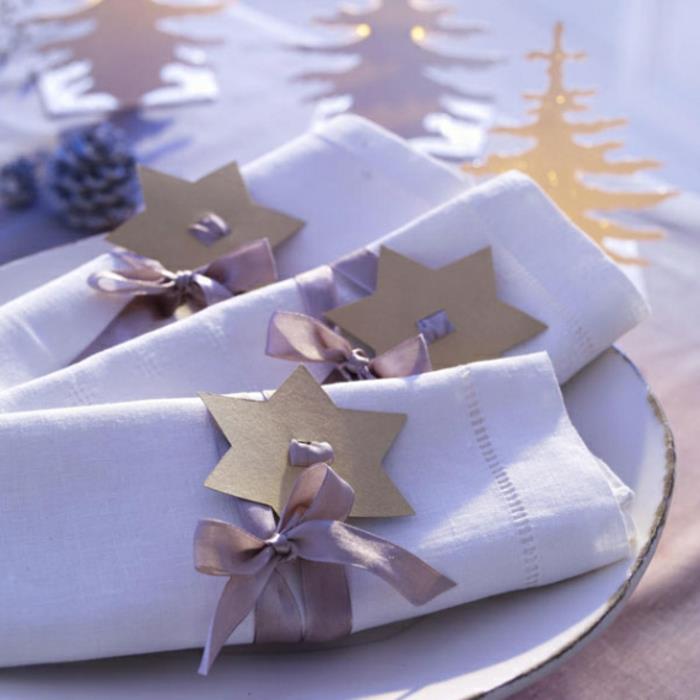 mucizevi Noel dekorasyonu, katlanmış kumaş peçeteler, karton yıldızlar ve çıplak renkli kurdeleler, küçük dekoratif iğneler