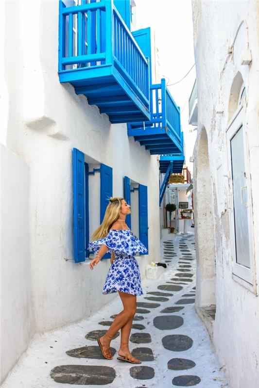 Grško modra na zunanjih polknih, pobeljene fasade, dekle v modro -beli obleki