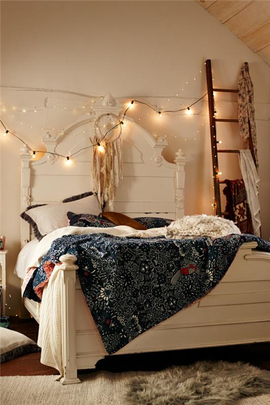 apdaila su šviesiomis girliandomis, balta lova, nuožulnus stogas, barokinė galvūgalis, bohemiška antklodė, dekoratyvinės kopėčios