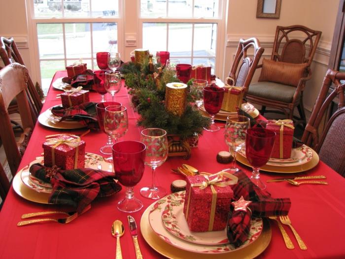raudona staltiesė, dovanos, įvyniotos į ryškiai raudoną popierių, pušies šakos, kalėdinių spalvų servetėlės, senovinės kėdės, lėkštės su gėlių motyvais