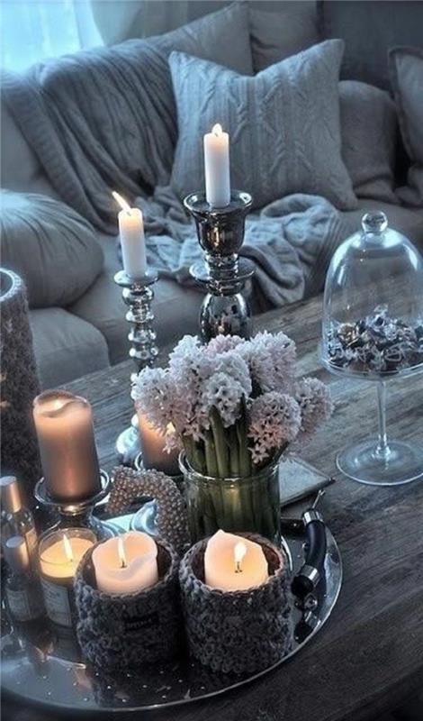 Šiaurės stiliaus stalo dekoravimas, sidabrinės žvakidės, didelė puokštė hiacintų, stiklinė saldainių dėžutė ir baltos žvakės