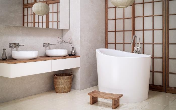 Azijietiškas vonios kambario dizainas baltos ir medinės spalvos su maža atskirai stovinčia vonia, vonios kambario apdaila su šviesiai pilkomis sienomis su medžio akcentais