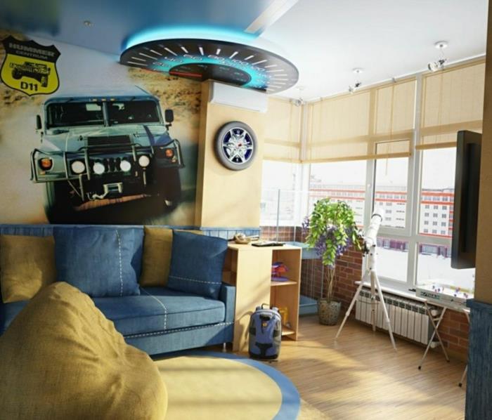 automobilio plakatas, mėlyna sofa, didelis osmanų ir šviesios spalvos kilimas, geltonos ir mėlynos spalvos berniuko kambario dekoras
