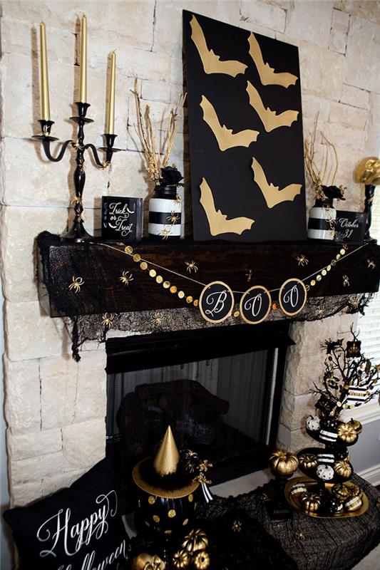 iç dekorasyon, bej taş duvarlı oturma odası, çelenkle süslenmiş siyah şömineli ve Cadılar Bayramı için siyah ve altın objeler