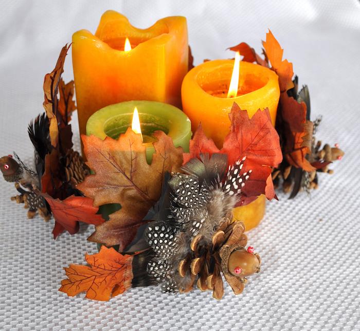 dekorativna kompozicija pisanih sveč z jesenskimi listi, borovimi storži in želodom, jesenskim dekorjem, ki ga naredite sami