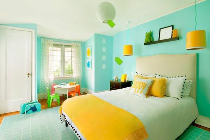 turkizna spalnica, rumena posteljna prevleka, okrasne blazine, zelena preproga, majhni stoli