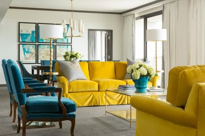mavi ve sarı zarif oturma odası dekoru, sarı kanepe ve koltuk, ahşap sandalyeler, ördek mavisi minder ve sırtlık, coğrafi haritalar duvar dekoru, gri halı