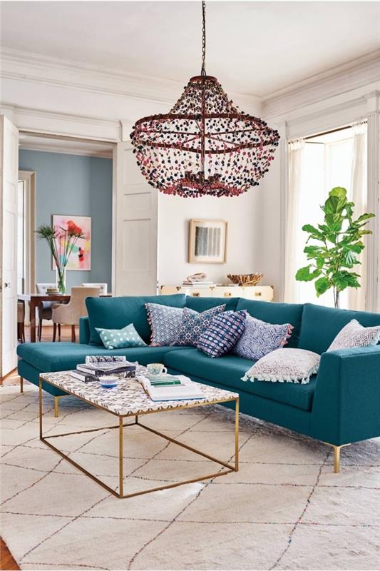 Bir oturma odasında ördek mavisi dekor nasıl benimsenir, beyaz bohem şık tarzı bir oturma odasının merkezi parçası haline gelen mavi yeşil köşe kanepe