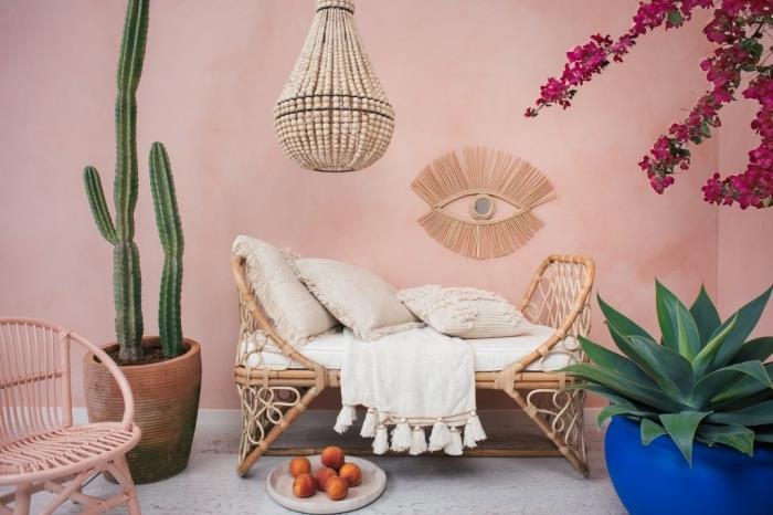 idėja, kaip dekoruoti atogrąžų stiliaus rotango svetainę rožiniais sienų dažais ir rotango bei bambuko pluošto baldais