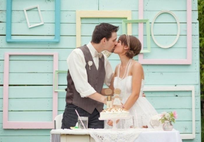 prazna dekoracija okvirja kmečka elegantna poroka, okvirji različnih formatov rumena, zelena, roza in modra, na steni iz desk prebarvana v zeleno, poročna torta, zaljubljen par