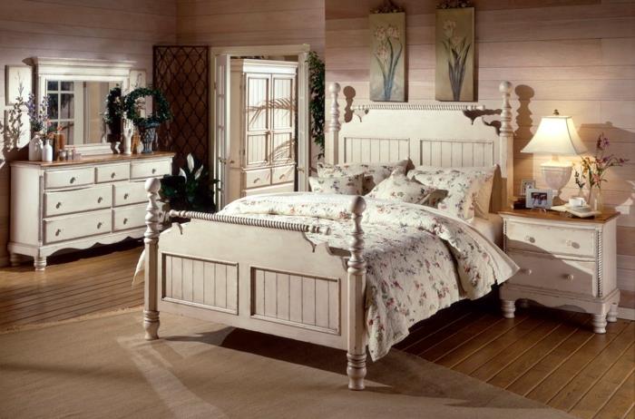 Ideja za spalnico v slogu podeželskega sloga, rjavi leseni parket, postelja iz belega lesa, posteljnina iz vzorca liberty, klasična komoda, lesena stenska obloga, cvetlične okrasne plošče