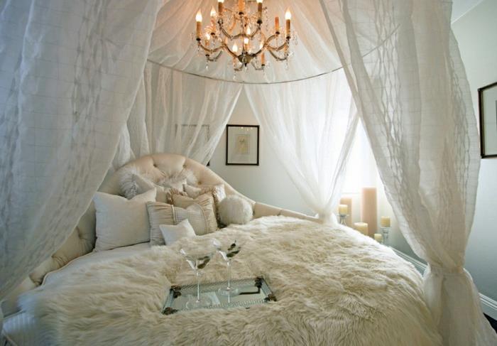 boudoir spalnica, bele tančice, oblazinjeno vzglavje, črni okvirji za fotografije, bele stene, sveče