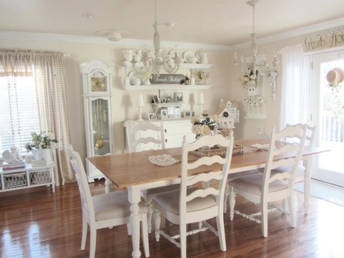 elegantna podeželska miza, leseni stoli, bela namizna posoda, bela omara za shranjevanje, rjav parket, vintage svetilka