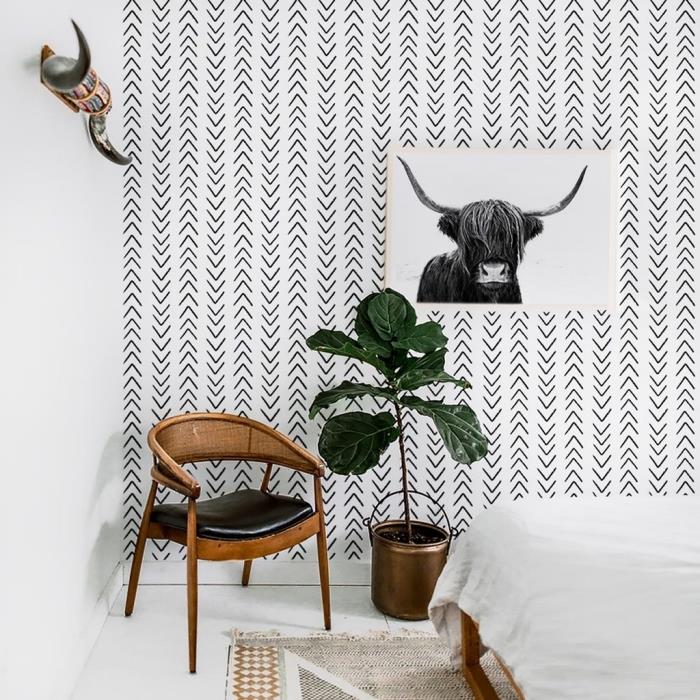 prašmatniu bohemišku stiliumi dekoruotas kambarys su baltos ir juodos spalvos sienų apdaila ir mediniais baldais, smėlio ir balto bohemiško kilimo raštu