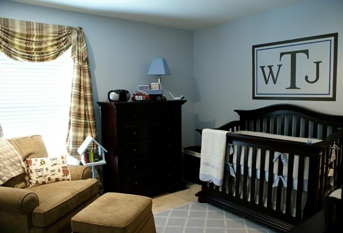 kūdikio berniuko kambario dekoras, juoda kūdikio lova, rudas fotelis, tamsaus medžio komoda