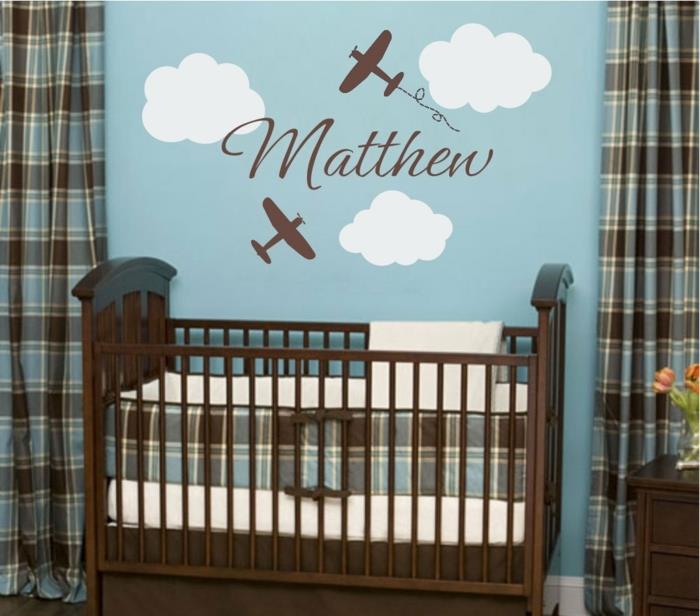 kūdikio berniuko kambario dekoras, mėlyna siena su baltais debesimis, kvadratinio rašto užuolaidos