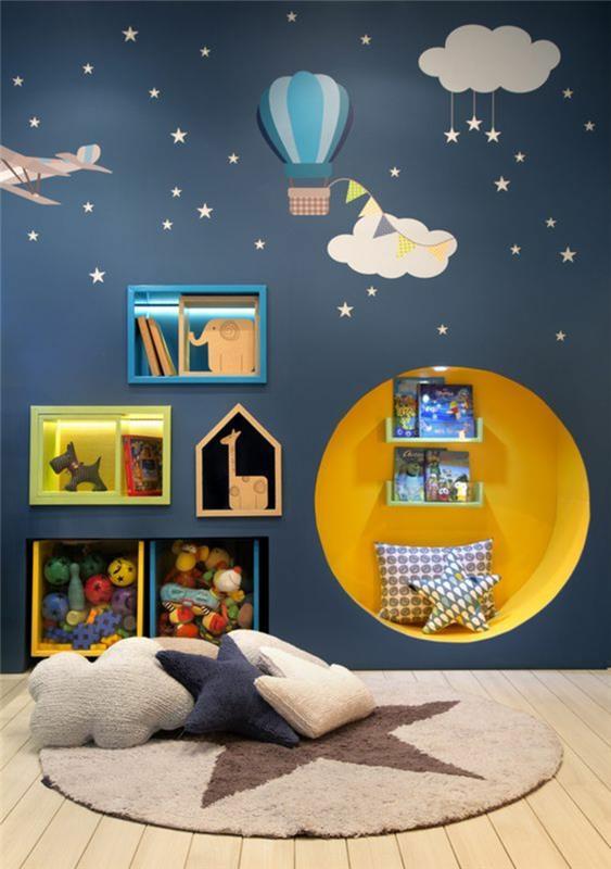 mavi bebek odası dekoru ördek ile mavi duvar yıldızlar, bulutlar ve sıcak hava balonu süslemeleri ile sarı renkte yuvarlak şekilli duvar nişi