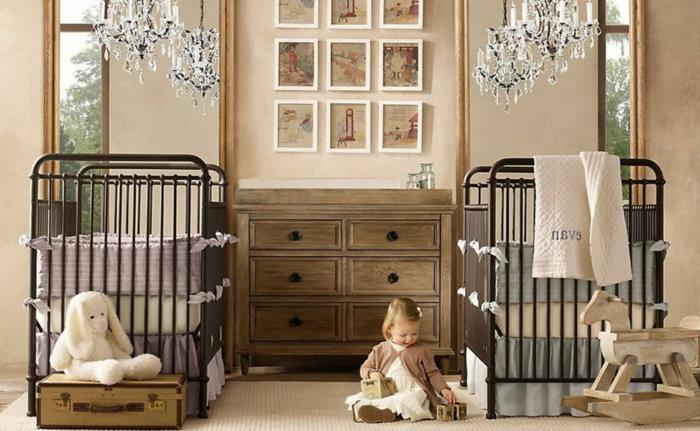 mišrus kūdikio kambario dekoras, dvi lovos, seno stiliaus medinė komoda, kutu lubų šviestuvai