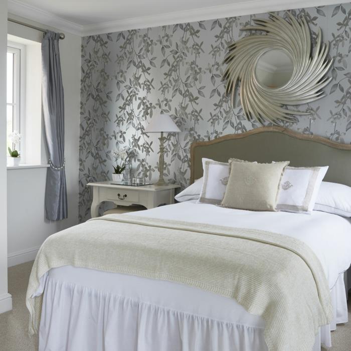 perlų pilkos spalvos tapetai, dekoratyvus saulės veidrodis, baltas barokinis naktinis stalas, senovinis baltas lovos komplektas