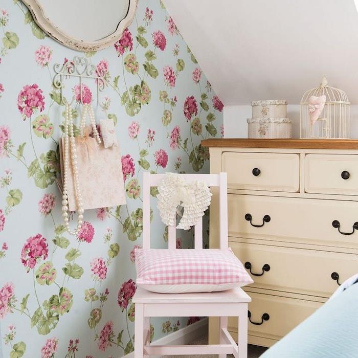 country şık tarzı yetişkin yatak odası dekoru, çiçekli yatak odası halısı, mavi arka planda pembe çiçekler, bej şifonyer, pembe eski sandalye, kuş kafesi dekorasyonu