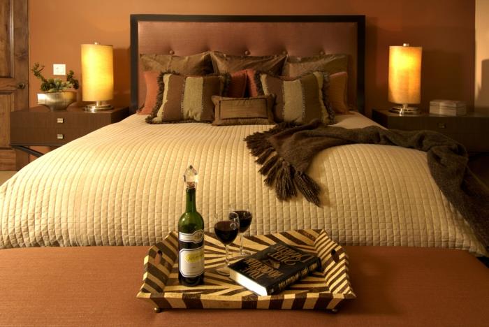 udobna postelja z bež odejo, trendovska dekoracija spalnice zen, dve cilindrični nočni svetilki