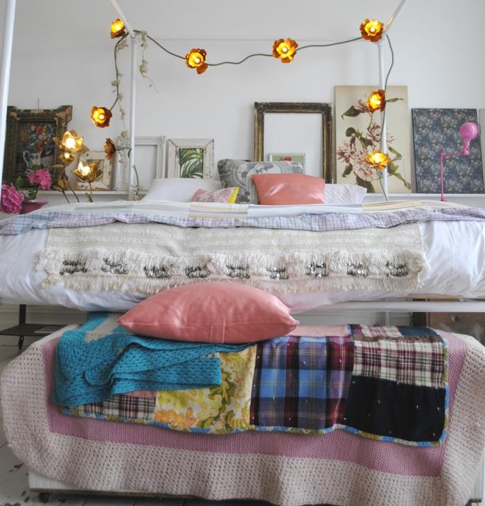 įrėminti paveikslai, šviesi girlianda, rožinės pagalvėlės, romantiškas miegamasis
