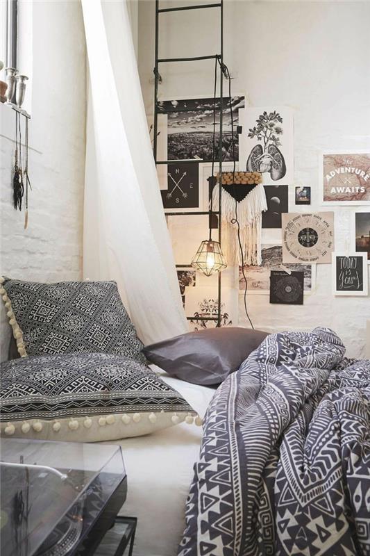gražus suaugusiųjų miegamasis, pilkos ir rožinės spalvos miegamojo dekoras, pilkos pagalvėlės, mūrinė siena, narvo lempa, juodos kopėčios