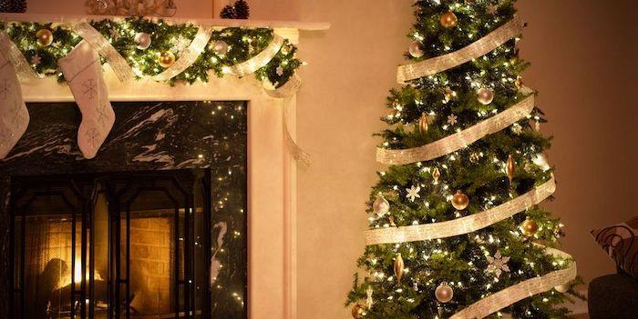 Noel şöminesi dekorasyonu bir Noel ağacı ve bir kurdele ile dolanmış yeşil çelenkler