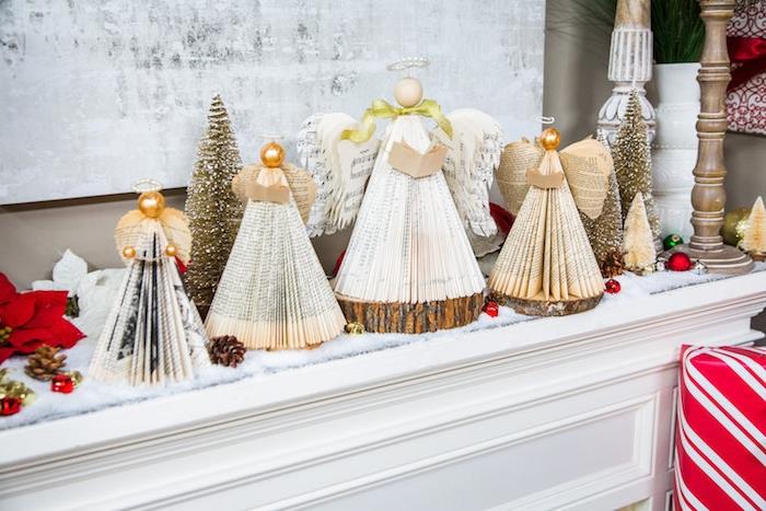 Kalėdinio židinio dekoravimo idėja popierinėse angelo figūrėlių knygoje ant medinių rąstų, kalėdinė puošmena, skirta pasveikti