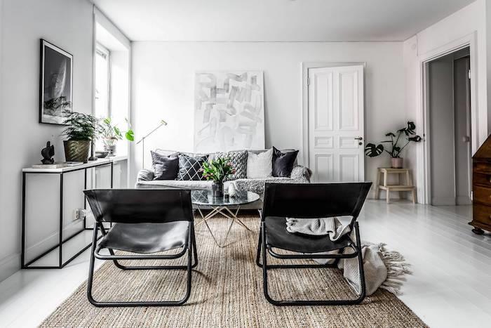 deco cocooning, siv kavč, bež preproga, črni usnjeni stoli, bele stene, pobeljen parket, oblikovalska mizica, siva odeja z ovojnico