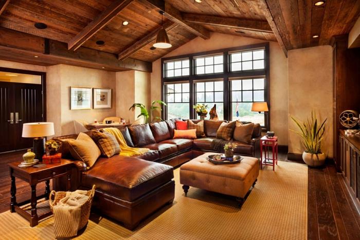 šiuolaikiškas dekoras, odinė sofa, senovinis kavos staliukas, geltonas kilimas, įvairiaspalvės pagalvėlės, medinis karkasinis namas, medinis parketas