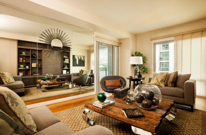 žalio medžio kavos staliukas, rudas kilimas, pilka sofa, pilkos pagalvėlės, didelis veidrodis, kaimiškas prašmatnus kaimiškas dekoras, šviesus parketas, odinis fotelis