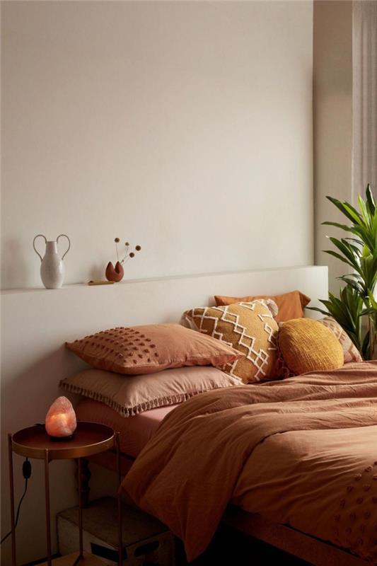 dekoro spalvos terakotos dizaino miegamasis boho minimalistinis apvalus metalinis stalas Čederio geltona pagalvėlė su makrame siuvinėjimu pom poms