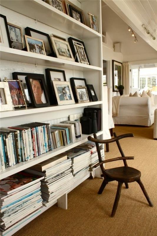 Biblioteka su knygomis ir dekoratyvinėmis nuotraukomis, medinė kėdė siauras ir ilgas kilimas prieškambariui, kaip papuošti siaurą prieškambarį