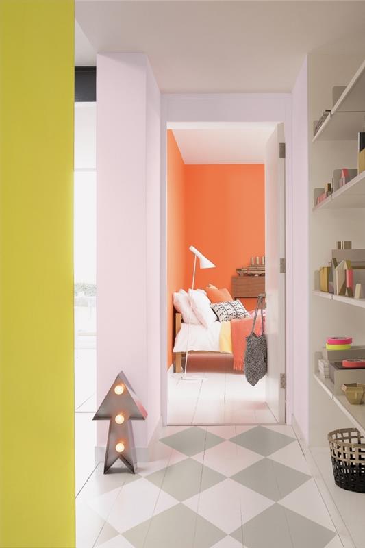 Ozka grafična dekoracija hodnika, oživljena s pridihi fluorescentno rumene in vitaminsko oranžne barve