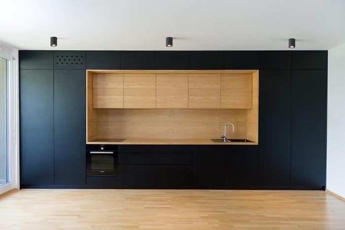 kaip sutvarkyti virtuvę su baltomis lubomis ir medinėmis grindimis su matiniais juodais virtuvės baldais