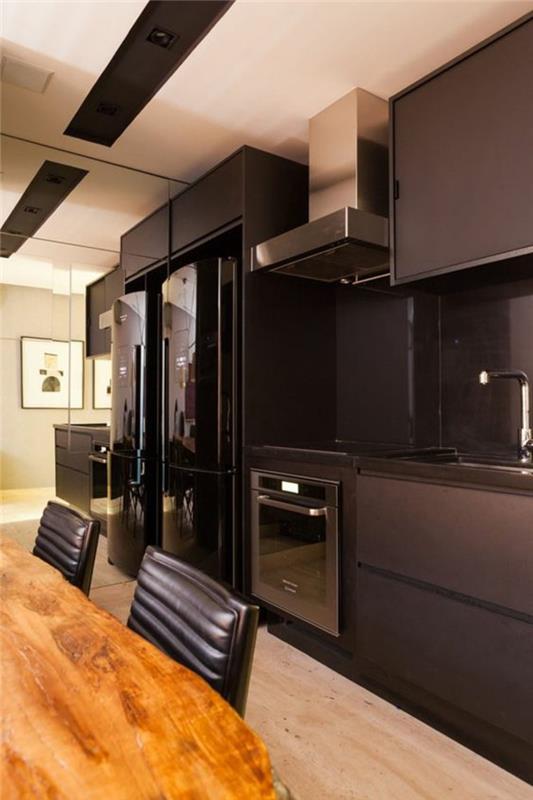 kaba ahşap masa ve iki büyük buzdolabı ile beyaz ve siyah tavan ile siyah mutfak