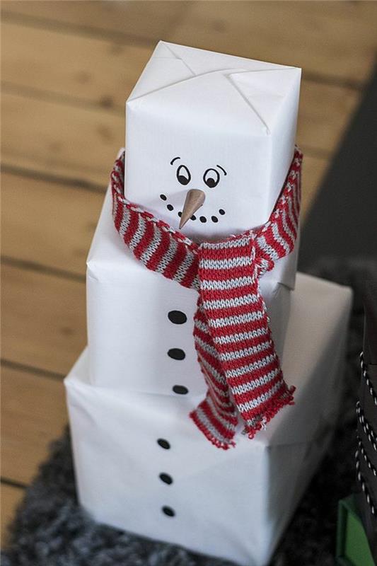 Božični snežak, izdelan s tremi belimi paketi in bombažnim šalom, z rdečimi in belimi vodoravnimi črtami, izvirna ideja za zavijanje družinskih daril