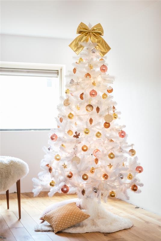 bakır tonlu Noel topları ile süslenmiş beyaz bir Noel ağacı ve koza beyaz bir örtü ile