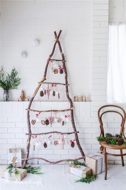 Beyaz tuğla duvar arka plan üzerinde ahşap el yapımı Noel süsleri ile dekore edilmiş, monte edilmiş ahşap dallardan yapılmış ahşap bir Noel ağacı ile rustik ve doğal şenlikli bir atmosfer