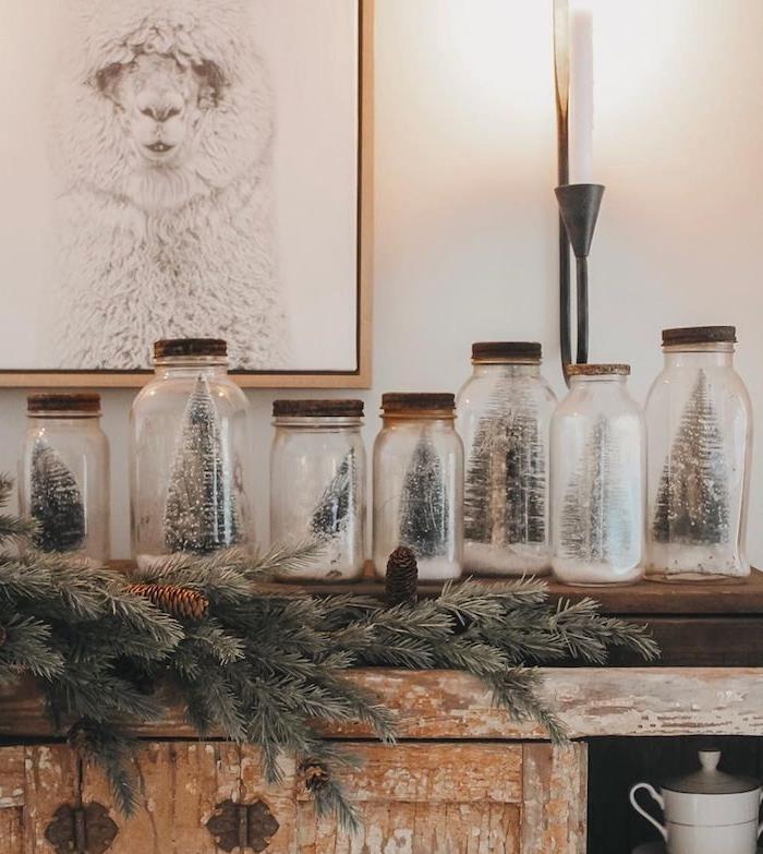stiklo indelių su mediniais dangteliais su dirbtiniu sniegu ir dirbtinių Kalėdų eglučių figūrėlių perdirbimas kaip Kalėdų puošmena, kad pasidarytumėte patys