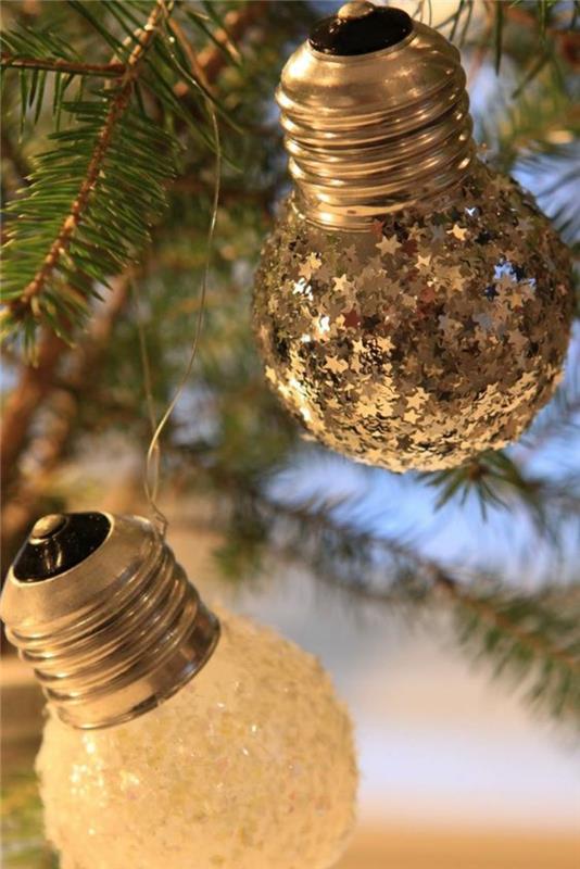 Kalėdų puošmena pasigaminti mažomis kriaušės formos lemputėmis, dekoruotomis mažomis sidabrinėmis žvaigždutėmis ir baltais elementais, imituojančiais šalną ant stiklo