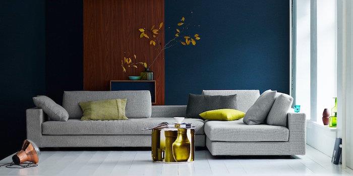 benzininė mėlyna spalva svetainės dekoravimui, pilka sofa ir žalios žalios spalvos pagalvėlės