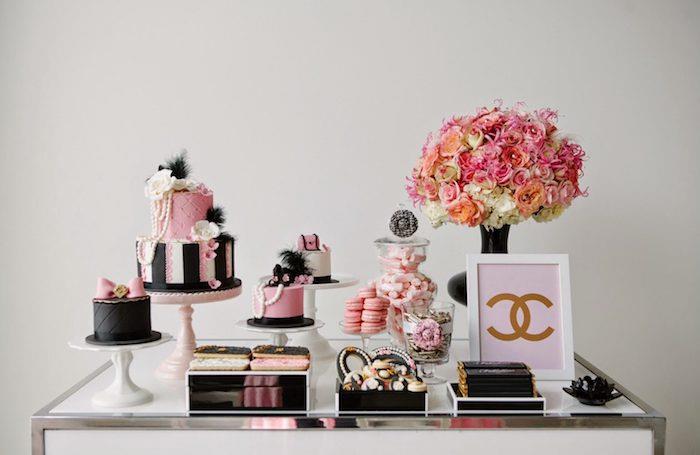gimtadienio vakarėlis teminiame kanale su juodais ir rožiniais pyragaičiais, rožinių ir baltų gėlių puokšte, rožiniais ir juodais pyragaičiais