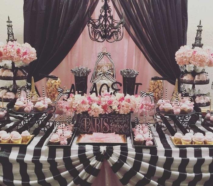 Paryžiaus tema suaugusiesiems skirtos gimtadienio šventės dekoracijos, rožinė ir juoda saldainių baro puošmena, rožinės gėlės, juodos ir baltos staltiesės keksiukai rožinė glazūra