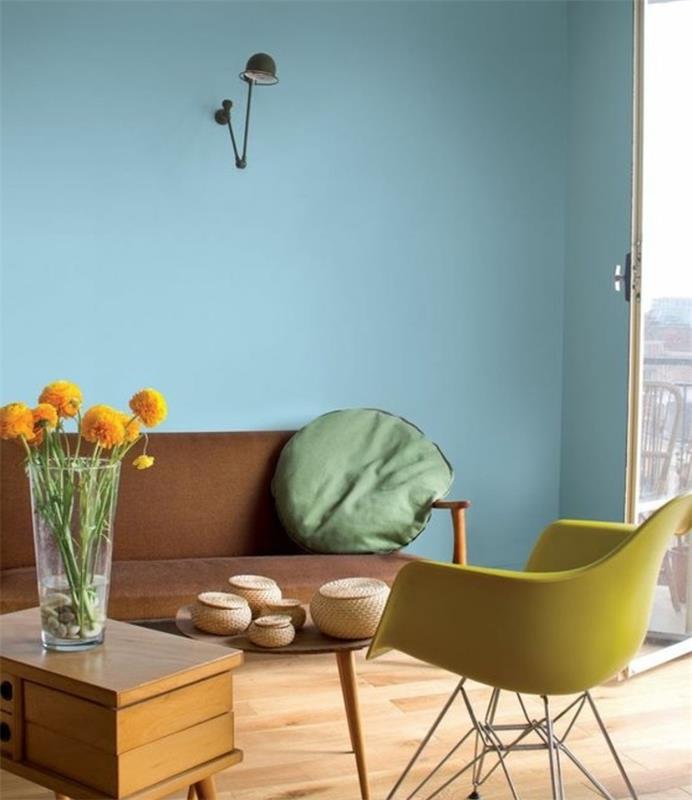 İskandinav oturma odası dekoru, sarı İskandinav sandalye ve pastel mavi duvar rengi, ahşap sehpa, kahverengi kanepe, yeşil minder