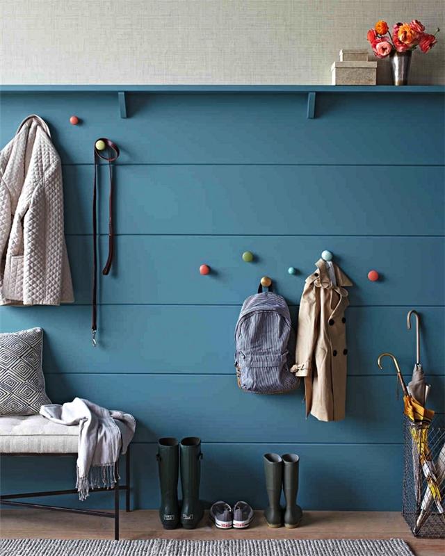 zamisel o dekoraciji vhodnega prostora z leseno podlago, pobarvano v modro modri barvi in ​​barvitimi okroglimi kljukami