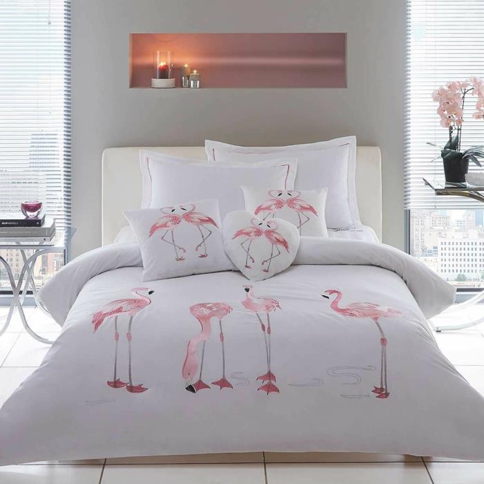 spalnica za odrasle, belo posteljnino s flamingi, velike blazine, belo vzglavje, stenska niša s svečami, biserno siva stena, eksotični dekor, ozadje flaminga